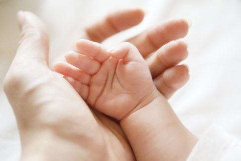 赤ちゃんの手を握る女性の手