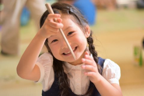 箸を持つ幼稚園の女の子