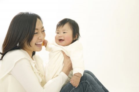 赤ちゃんを抱っこする笑顔のママ