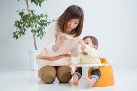 赤ちゃんに絵本を読む保育士