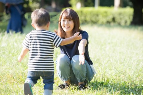 芝生でママに向かって走る2歳児