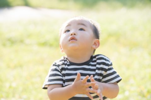 青空を見上げる赤ちゃん