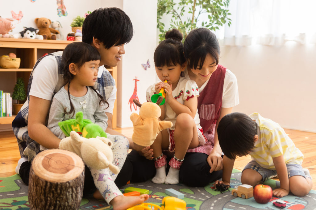 子供達と遊ぶ笑顔の保育士